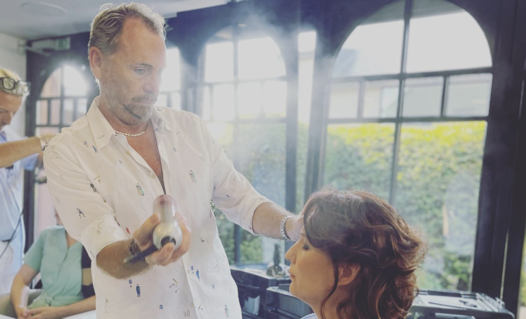 Kapper die kapsel afwerkt met haarlak in kapsalon